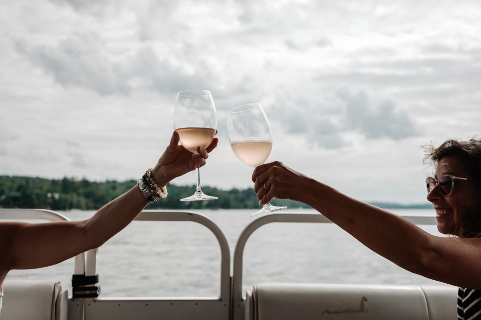 Personne qui apprécie un bon verre de vin sur Les Croisières L’air du Lac