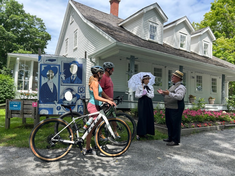 Comédien·nes et cyclistes devant la Maison Merry de Magog.