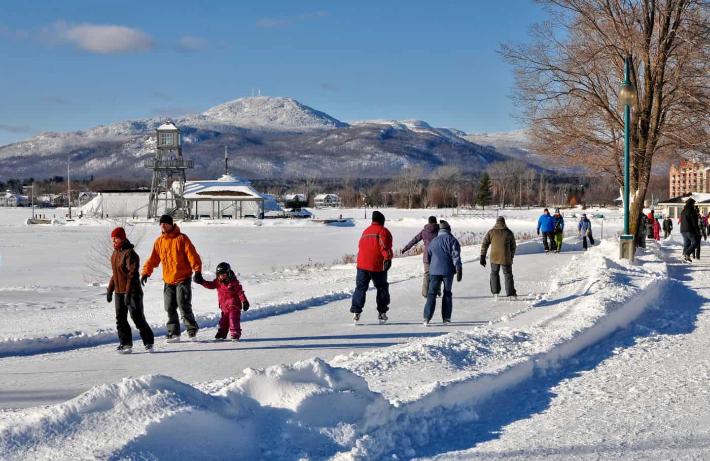 Personnes patinant sur le sentier glacé de Magog aux abords du lac Memphrémagog.