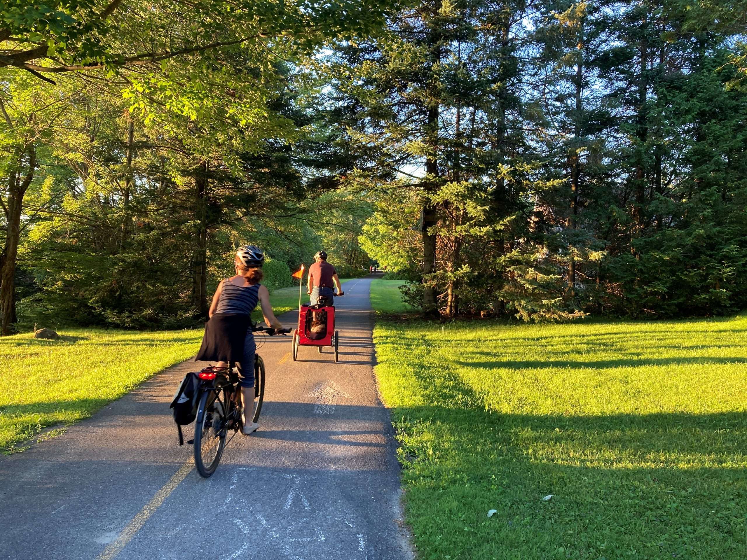 Personnes à vélo sur l'une des pistes cyclables de la région de Memphrémagog dans les Cantons-de-l'Est.