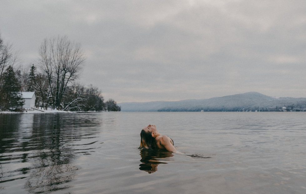 Femme se baignant dans le Lac Memphrémagog en hiver lors d'une activité Solstice sauna