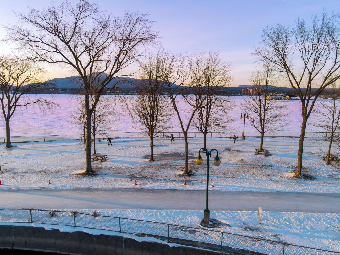 3 personnes patinant sur le sentier glacé de la pointe Merry aux abords du Lac Memphrémagog à Magog.