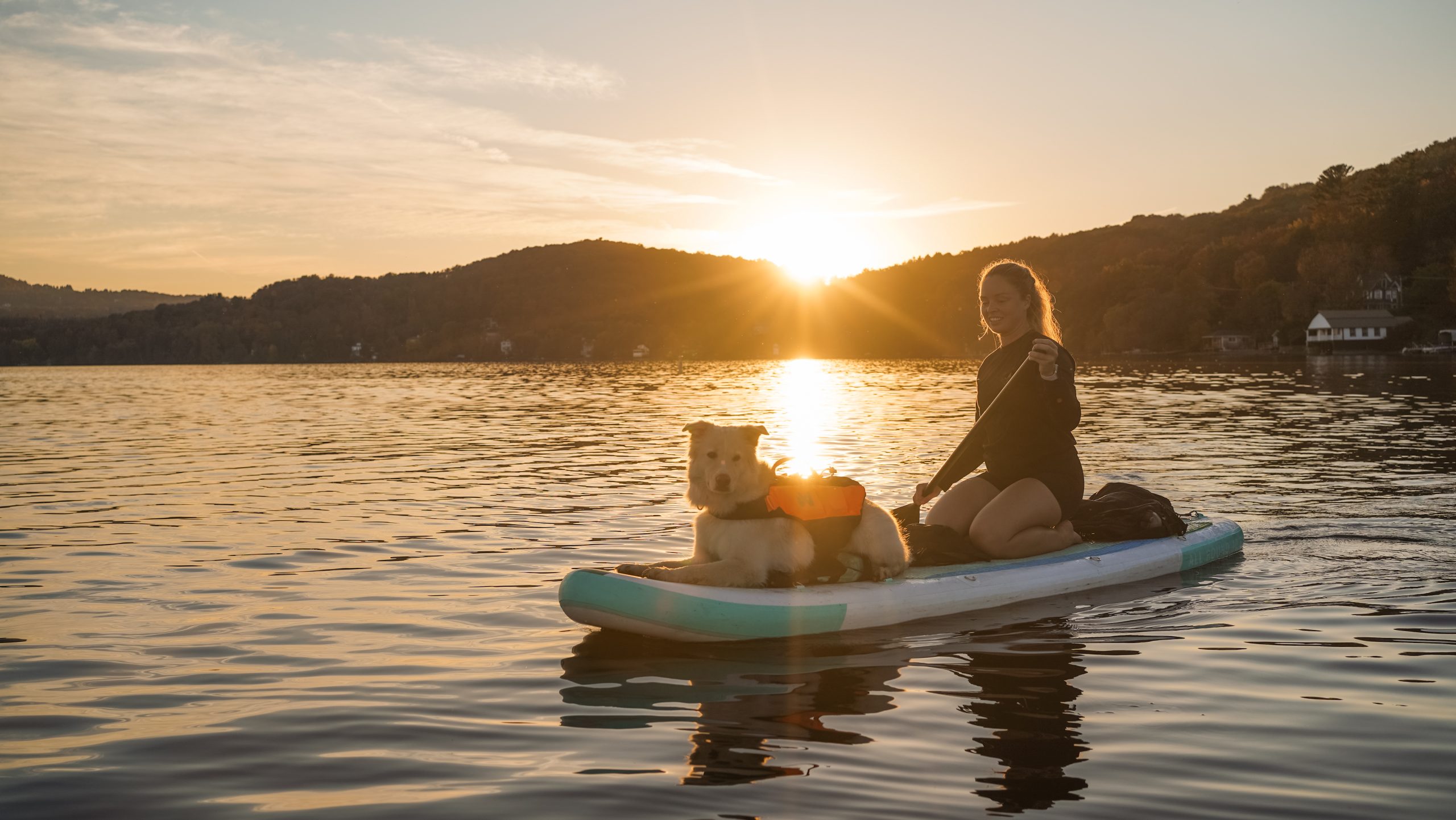 Femme avec son chien en planche à pagaie sur le lac Massawippi à North Hatley.